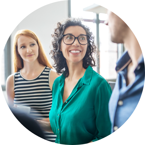 Woman in green shirt smiling at colleague